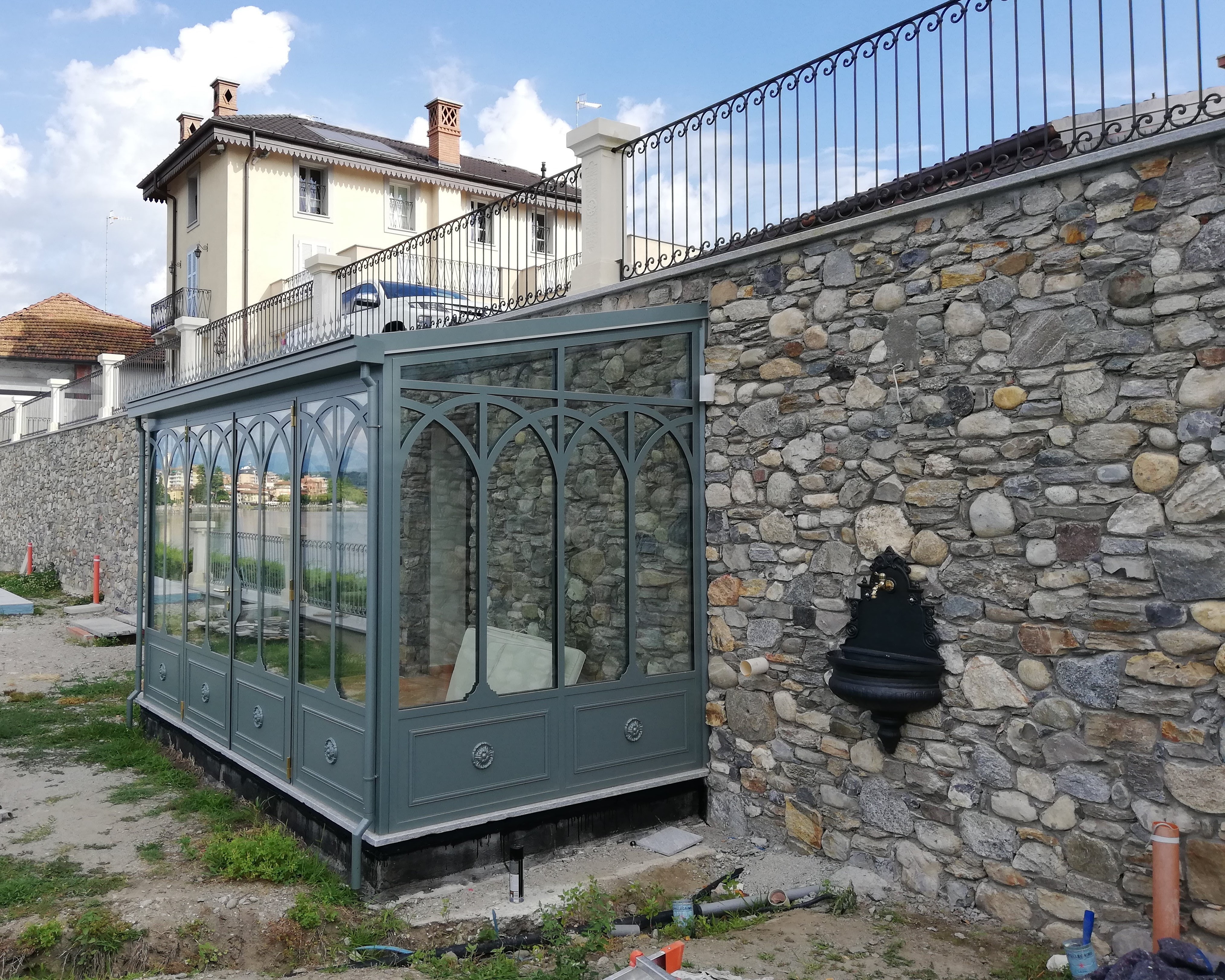 Veranda in ferro e vetro con muro in pietra a vista